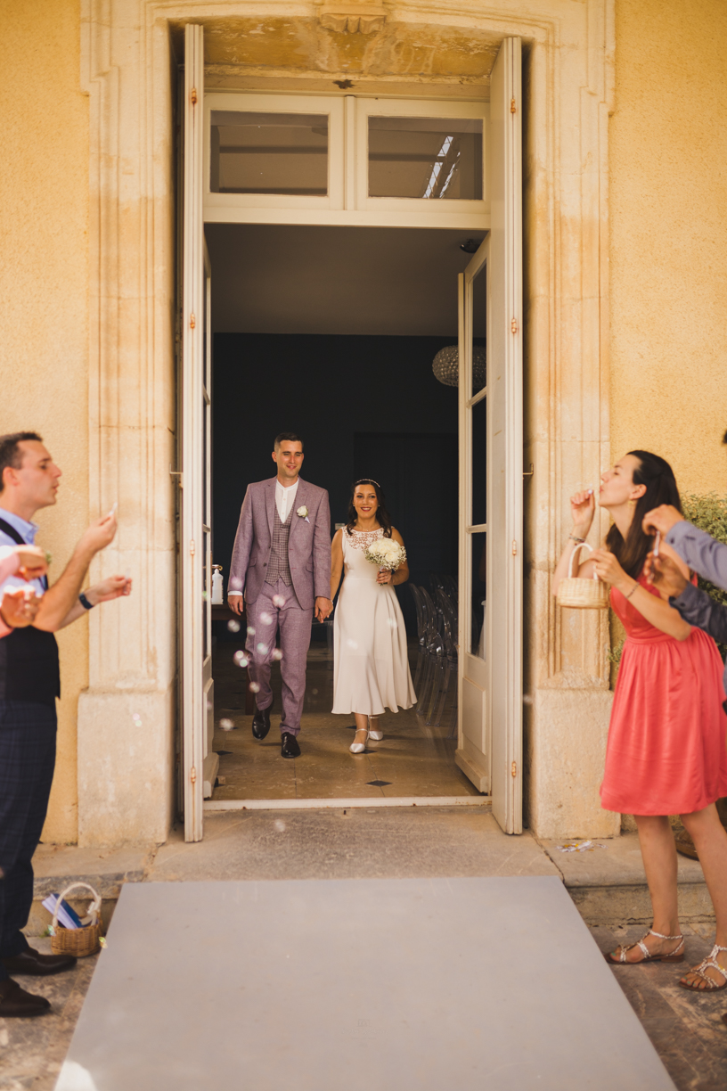 Sortie des mariés de la salle des mariages du château de Montplaisir de Narbonne sous une pluie de bulles soufflées par les invités.