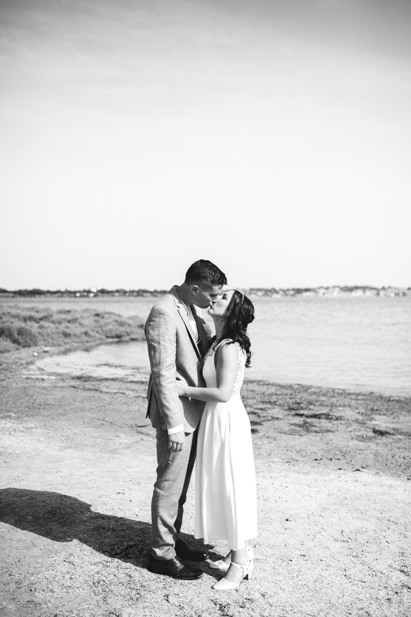 photo noir et blanc du couple de mariés au bord de l'Etang face à Gruissan ils s'embrassent.