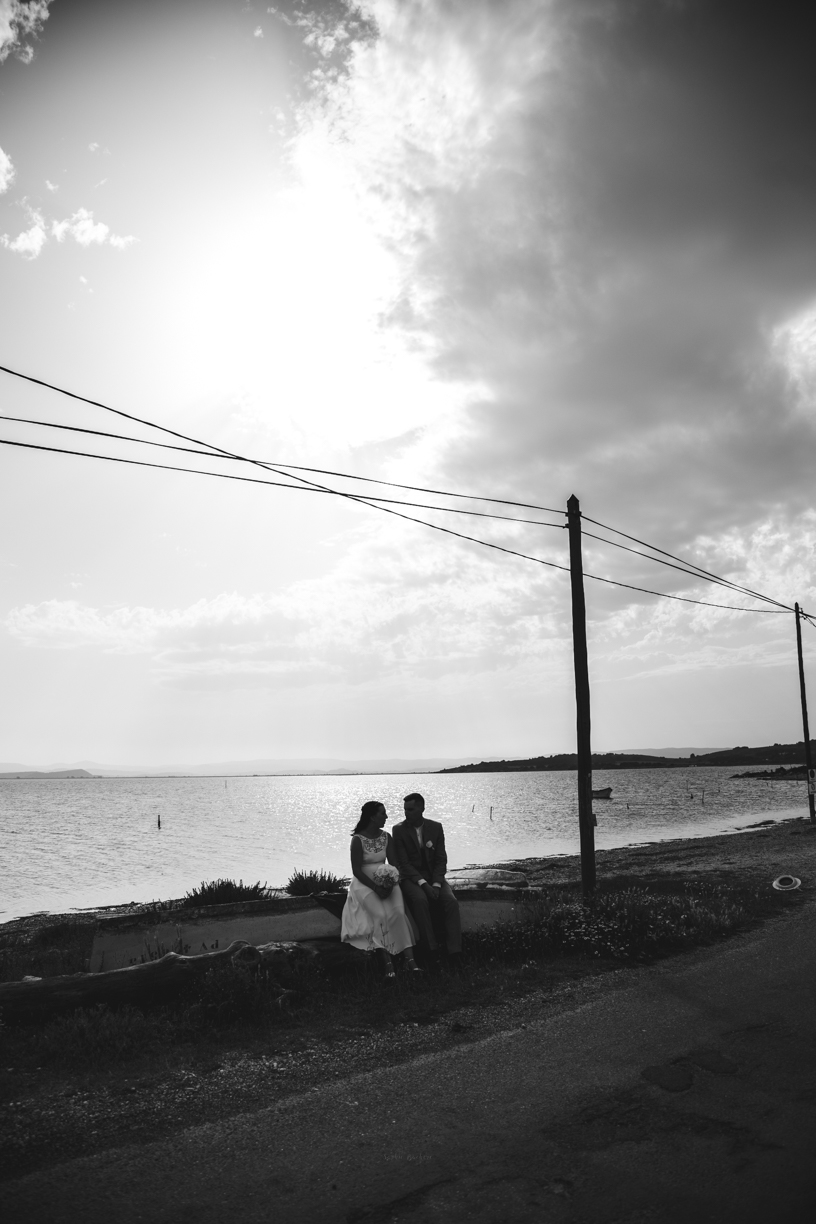 Mariage - photo noir et blanc, en contre jour on voit le couple assis sur une barque au bord de l'étang, sous un fils électrique