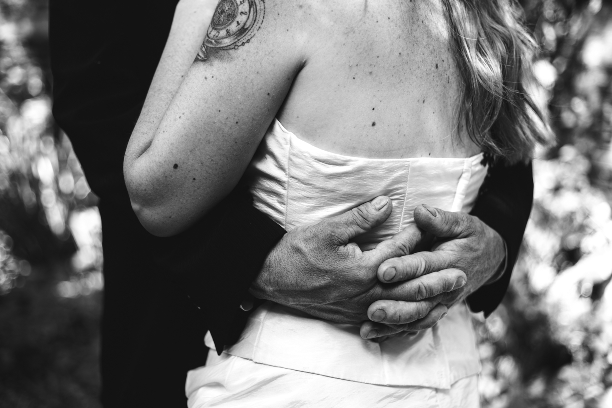 Photo noir et blanc où l'homme enlace sa femme dans ses bras