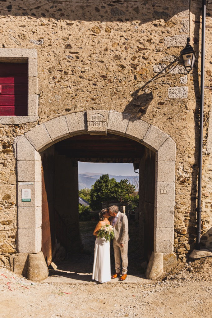Mariage - Photo des mariés sous un porche du village de Dorres dans les Pyrénées Orientale