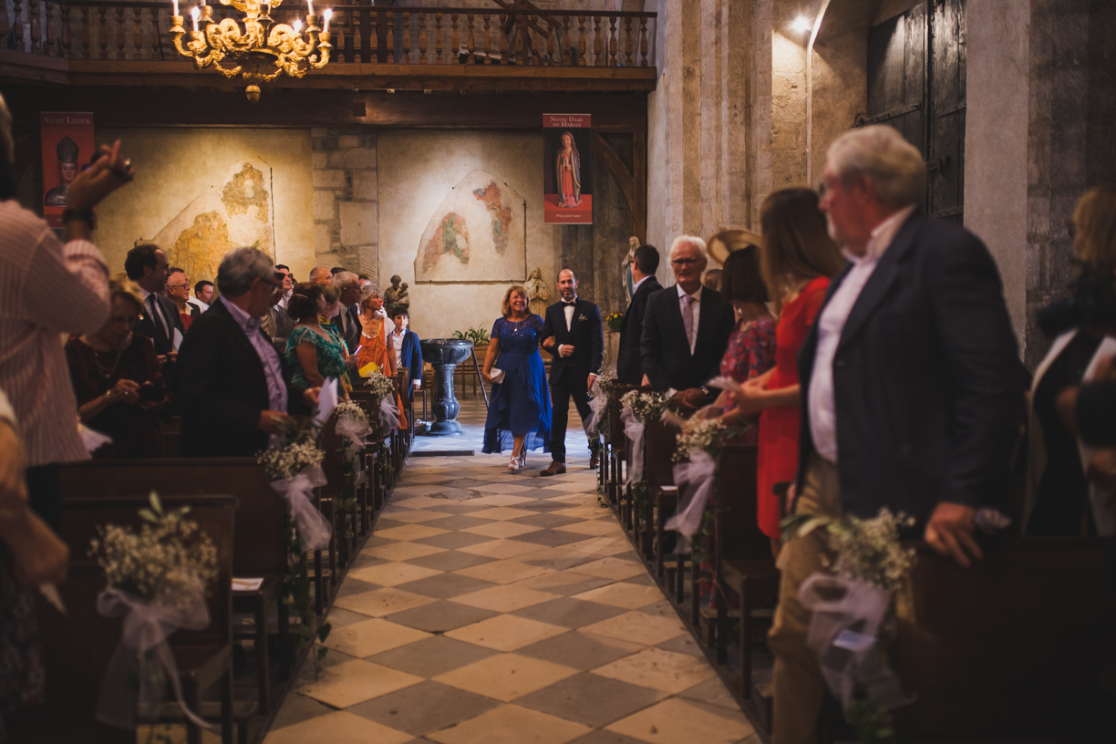 Le marié fait sa rentrée dans l'église au bras de belle-maman dans l'église de Saint Lizier en Ariège