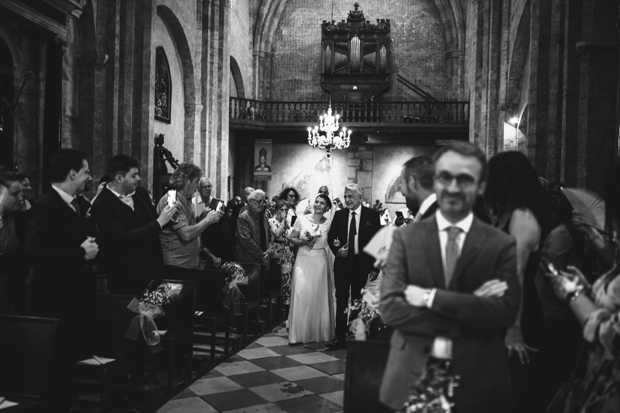 La mariée fait sa rentrée dans l'église sous le regard de son futur époux et des invités dans l'Eglise de SAINT LIZIER en Ariège