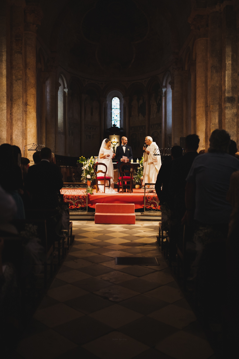 Vu des mariés face aux invités éclairés alors que le public est dans l'ombre dans l'église de Saint Lisier Ariège
