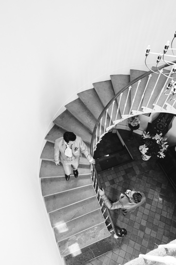 photo en noir et blanc inversée, où l'on voit en silhouette par terre les mariés s'embrassaient